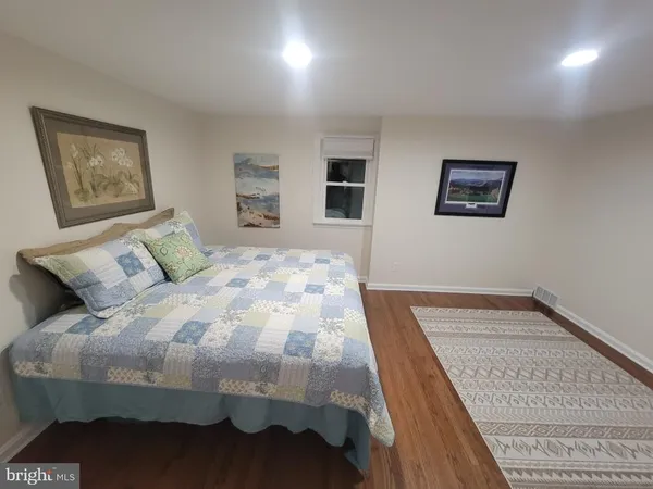 a bedroom with a bed and a lamp on dresser