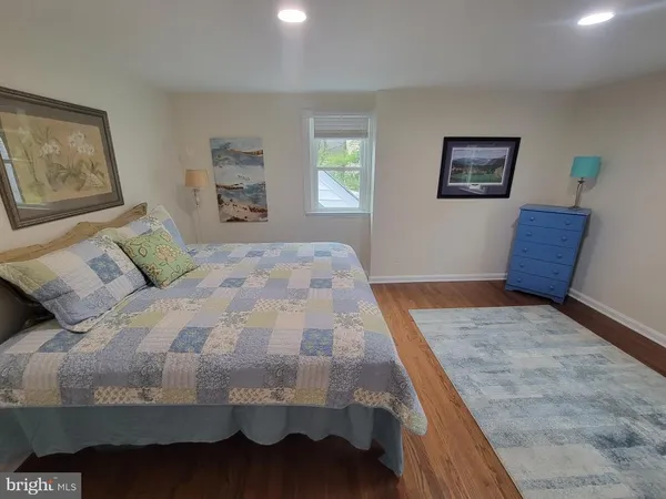 a bedroom with a bed and painting on the wall