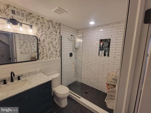 a bathroom with a sink a toilet and shower