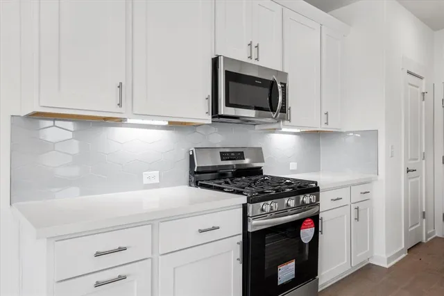 a kitchen with kitchen island granite countertop a sink a counter top space stainless steel appliances and cabinets