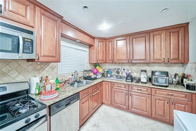 a kitchen with kitchen island granite countertop a sink stove and cabinets