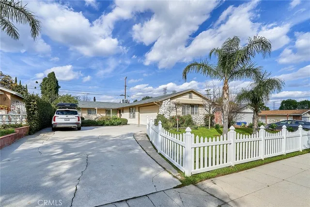 a view of a house with a small yard and wooden fence