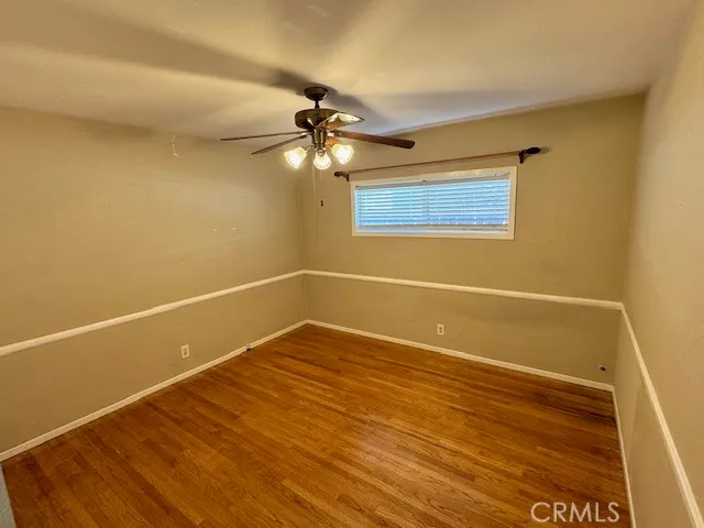 a view of a room with wooden floor and fan