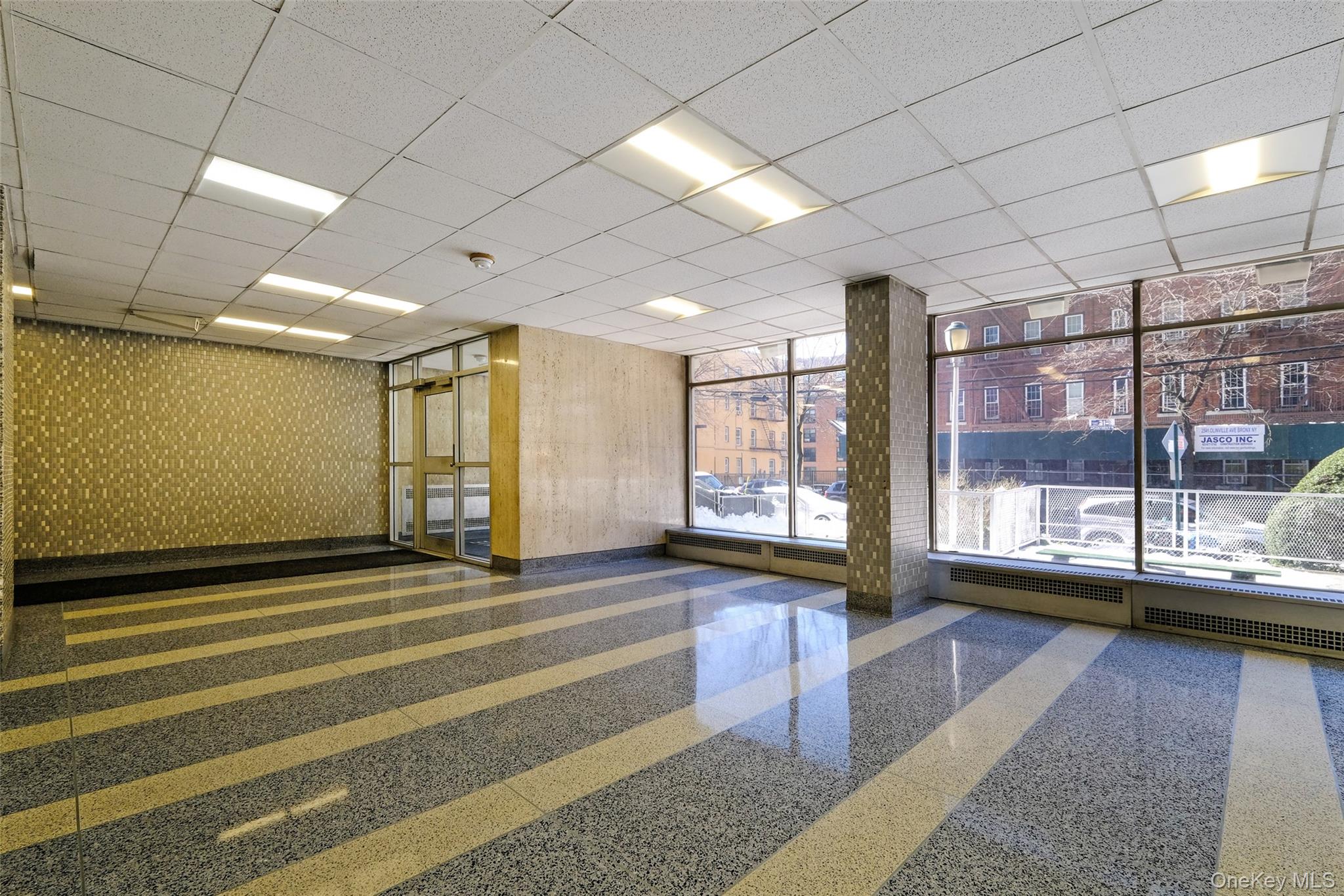 2550 Olinville Avenue, Unit 8H Bronx, NY 10467 - Photo 23 of 24 Lobby featuring a paneled ceiling and expansive windows