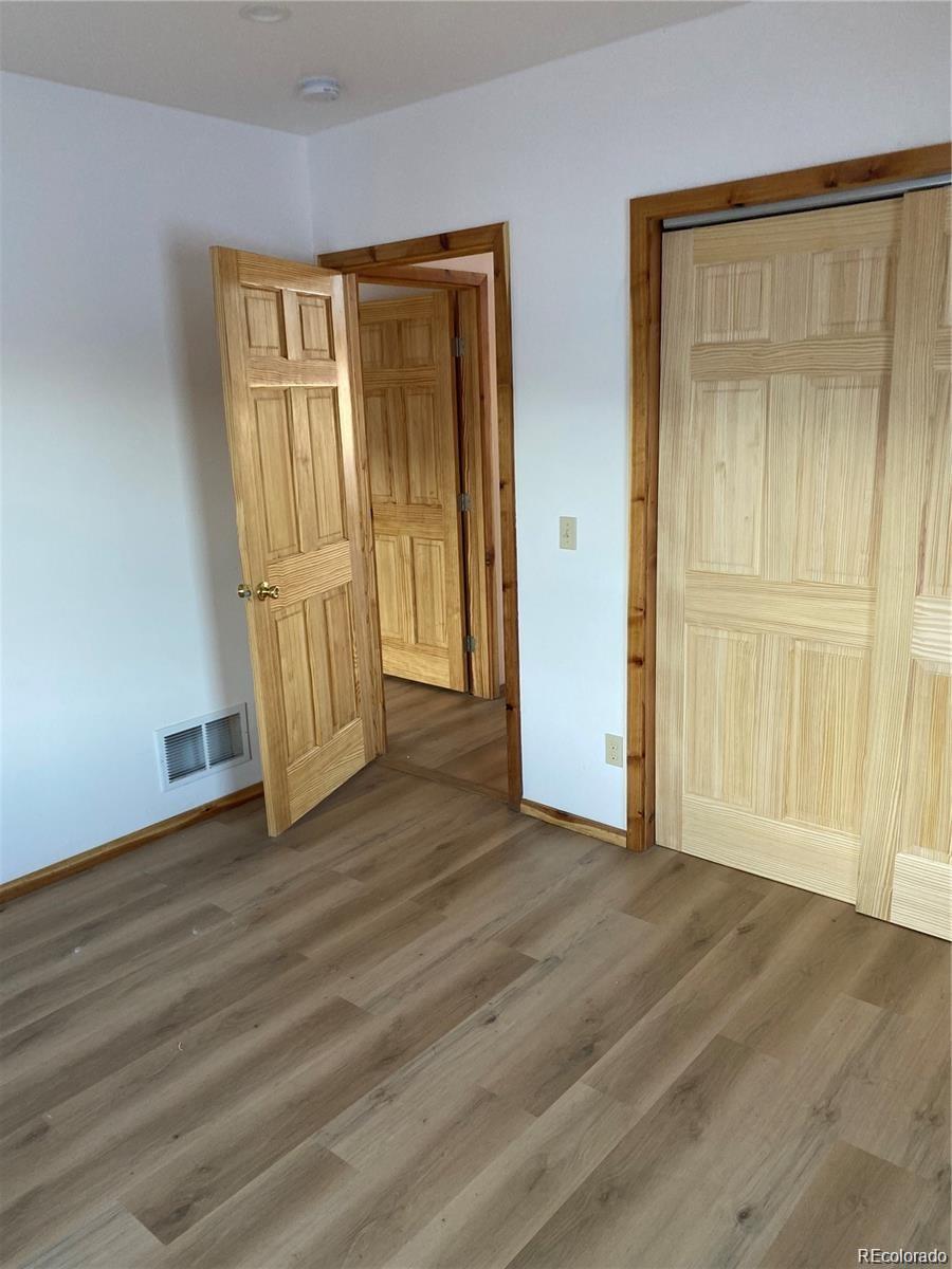 113 Nana Road Hartsel, CO 80449 - Photo 2 of 9 an empty room with wooden floor and windows