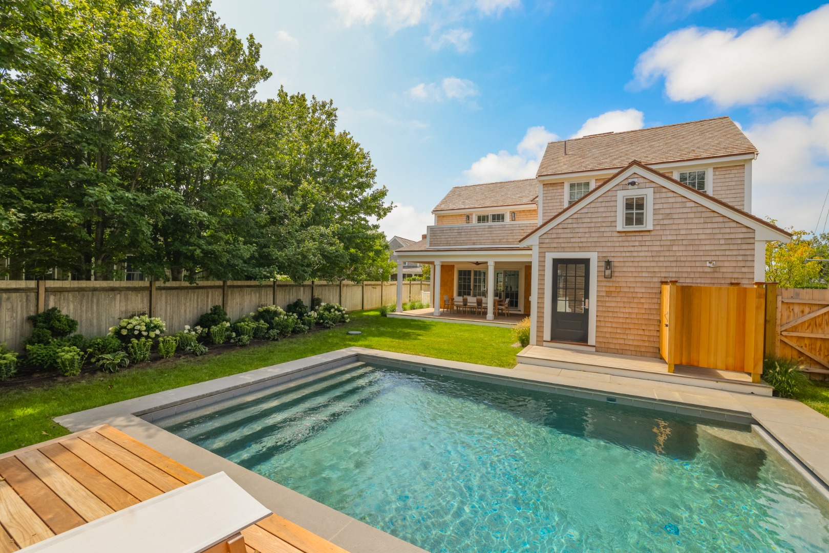 12 Derrymore Road Nantucket, MA 02554 - Photo 3 of 35 a front view of a house with a yard table and chairs