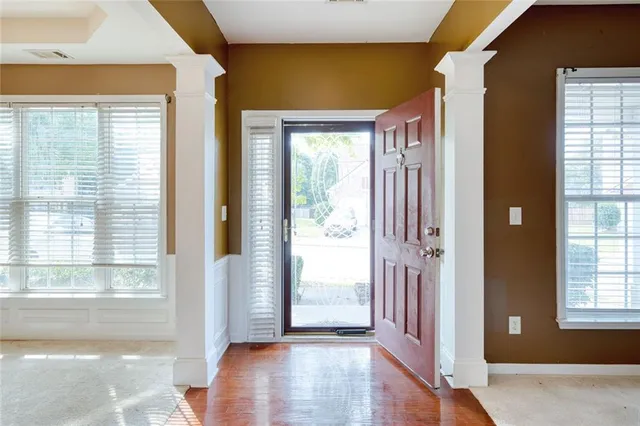 a view of a hallway with wooden floor and windows