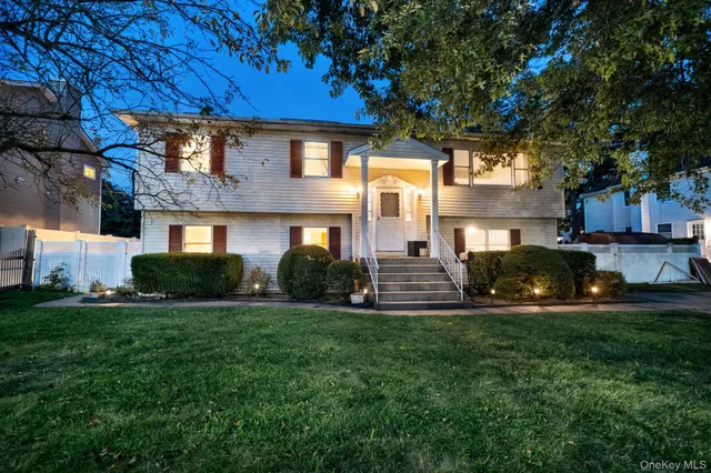 a view of house with backyard and sitting area