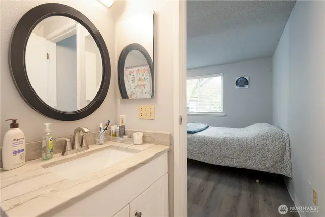 a en suite bathroom with a granite countertop double vanity and a mirror