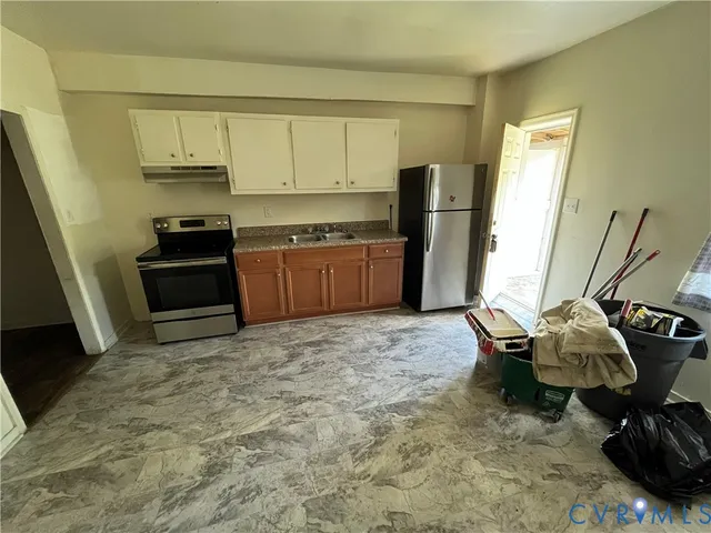 a kitchen with a refrigerator and a stove top oven
