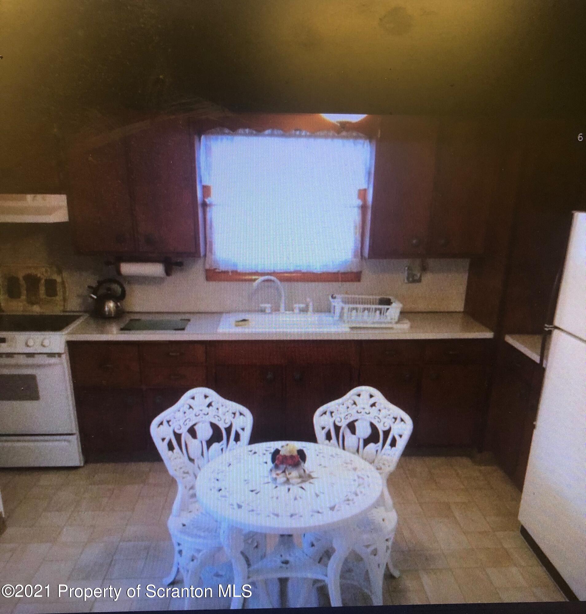 89 Belmont Street Carbondale, PA 18407 - Photo 18 of 26 a kitchen with a sink a stove and chairs