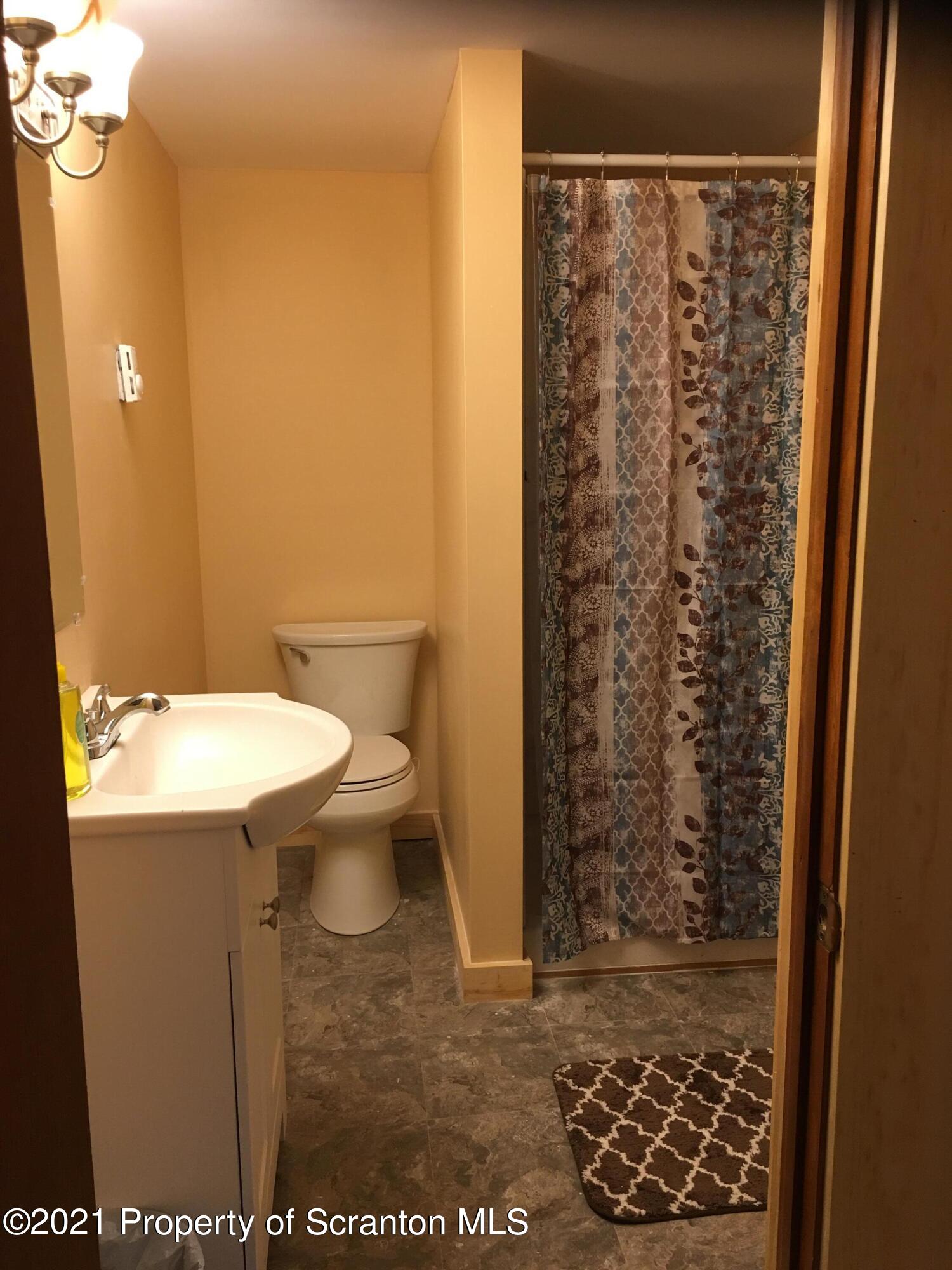 89 Belmont Street Carbondale, PA 18407 - Photo 19 of 26 a bathroom with a sink a toilet and shower