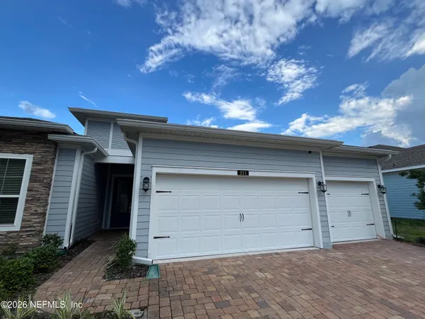 a view of a hallway with wooden floor a bathroom and a sink