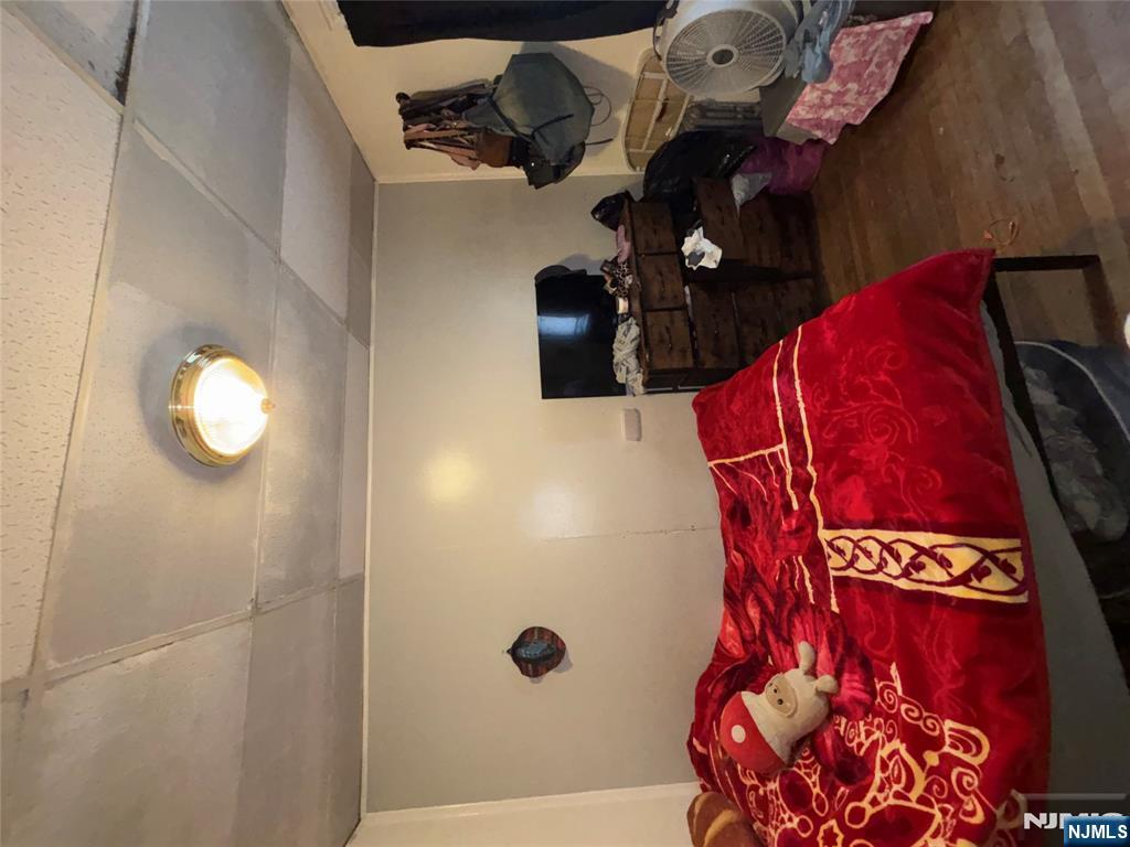 879 Madison Avenue Paterson, NJ 07501 - Photo 11 of 18 a bedroom with bed and a night stand