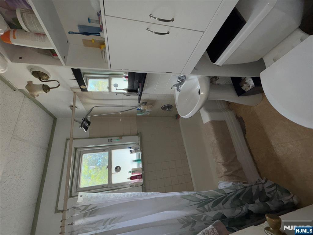 879 Madison Avenue Paterson, NJ 07501 - Photo 12 of 18 a bathroom with a sink a toilet and tub