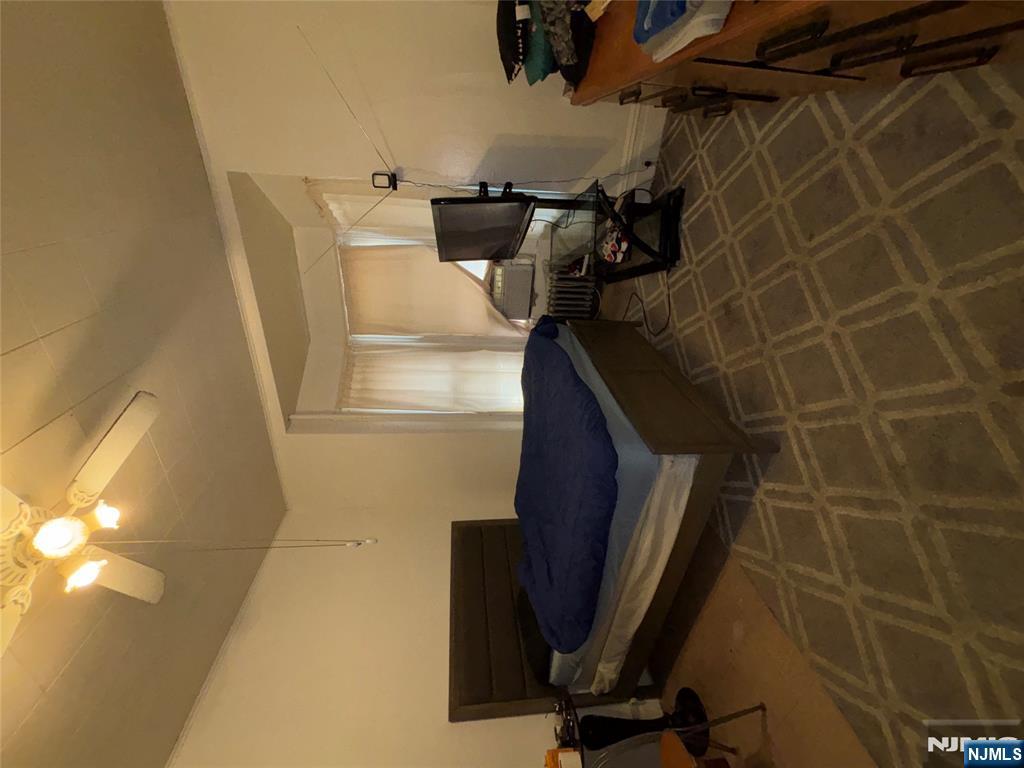 879 Madison Avenue Paterson, NJ 07501 - Photo 6 of 18 a living room with patio furniture and a flat screen tv