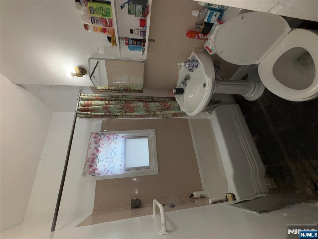879 Madison Avenue Paterson, NJ 07501 - Photo 7 of 18 a bathroom with a sink toilet and a bathtub