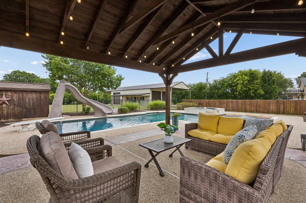 1700 Rock Ridge Road Lucas, TX 75002 - Photo 30 of 37 Relax beneath this outdoor living area overlooking the sparking pool. It's such a great pool for all ages with the spa, diving board, and slide!