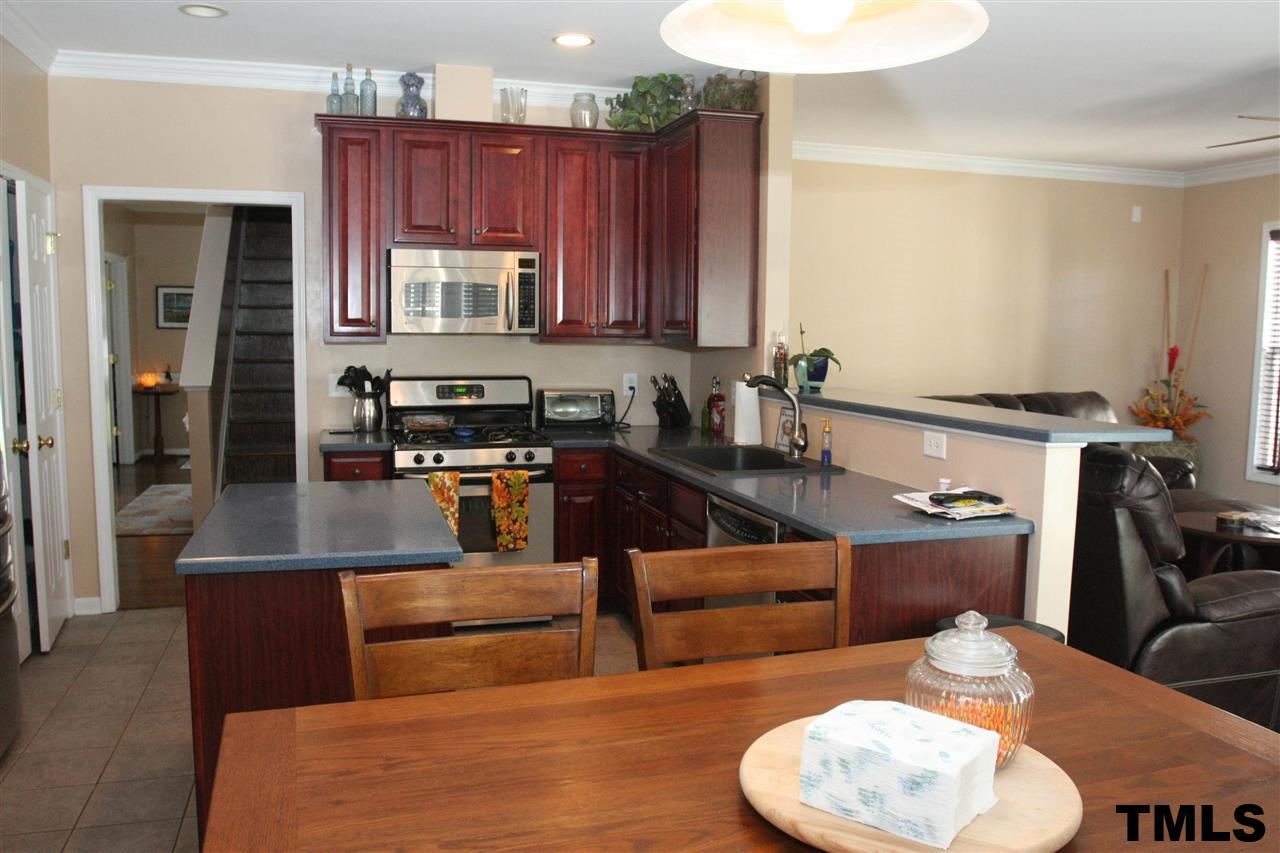 197 Mickleson Ridge Drive Raleigh, NC 27603 - Photo 11 of 25 a kitchen with kitchen island stainless steel appliances a sink a counter top space and living room view