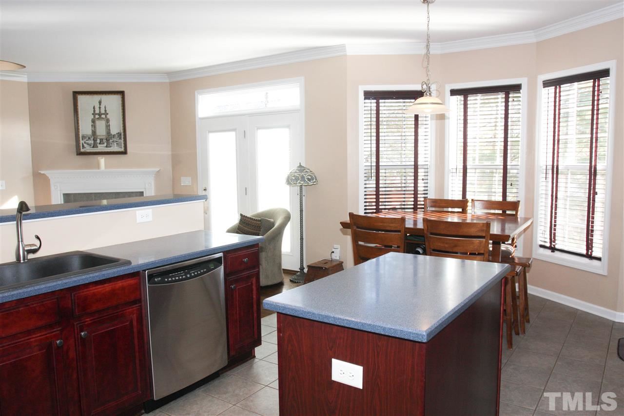 197 Mickleson Ridge Drive Raleigh, NC 27603 - Photo 6 of 25 a kitchen with a stove a sink and a wooden cabinets