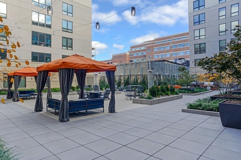 33 Rogers Street, Unit 201 Cambridge, MA 02142 - Photo 9 of 11 a view of a patio with a table and chairs under an umbrella