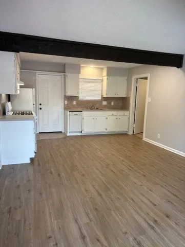 a view of a kitchen with wooden floor and electronic appliances