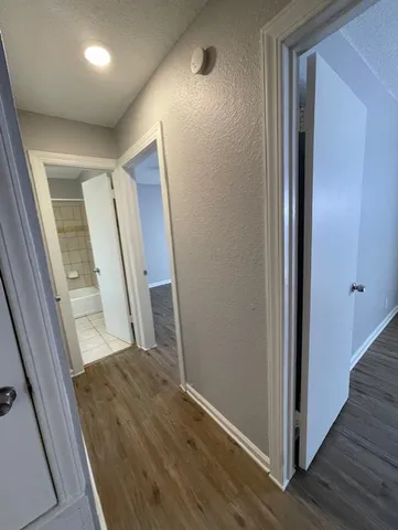 a view of a hallway with wooden floor and stairs