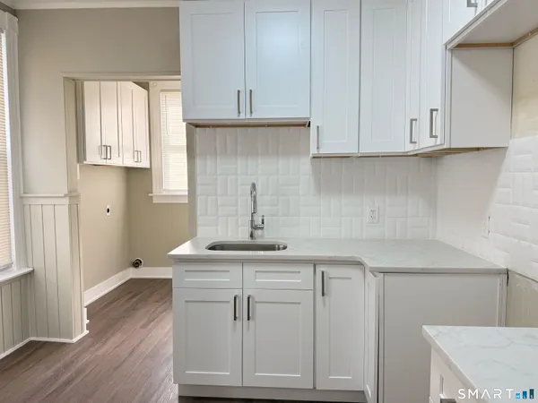 a kitchen with white cabinets and sink