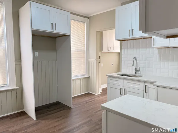 a kitchen with a sink a refrigerator and cabinets