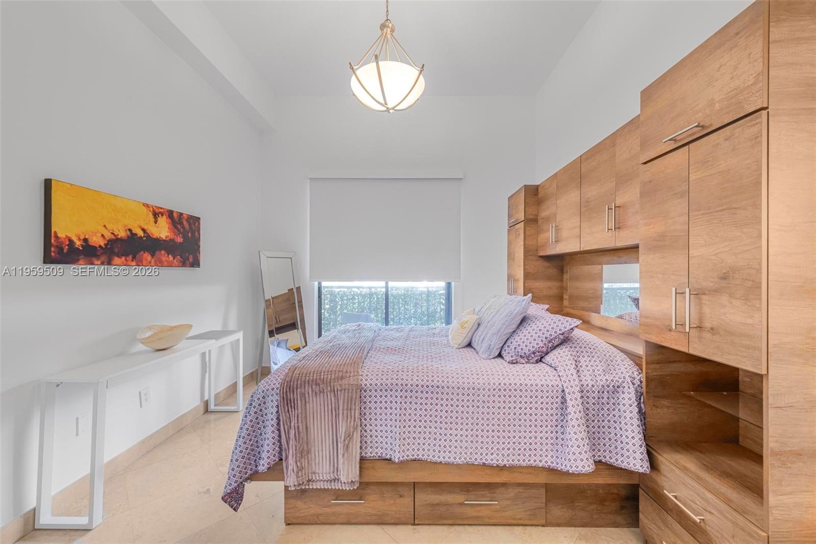 540 Brickell Key Drive, Unit 500 Miami, FL 33131 - Photo 15 of 26 a bedroom with a bed and a chandelier