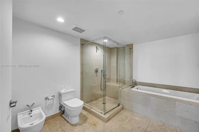 a bathroom with a toilet a sink and shower