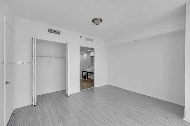 a view of empty room with wooden floor