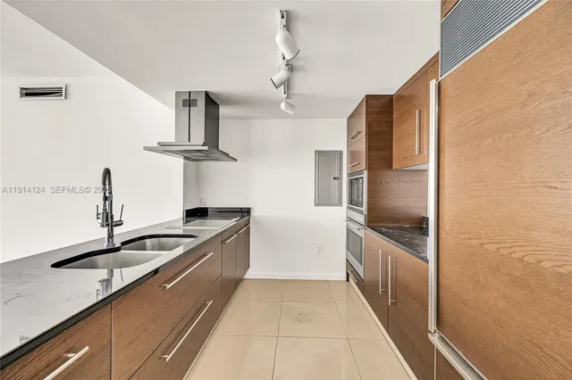 a kitchen with granite countertop a sink and stainless steel appliances