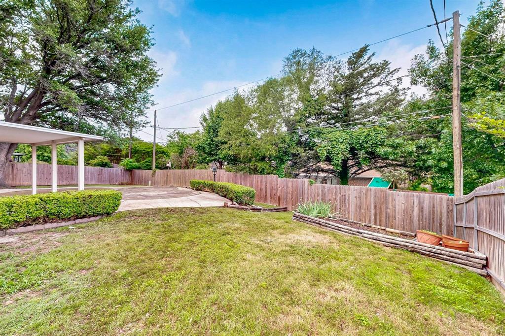 3965 Singleleaf Lane Fort Worth, TX 76133 - Photo 33 of 39 Expansive backyard featuring a manicured lawn, established privacy fencing, mature trees, and a covered patio area