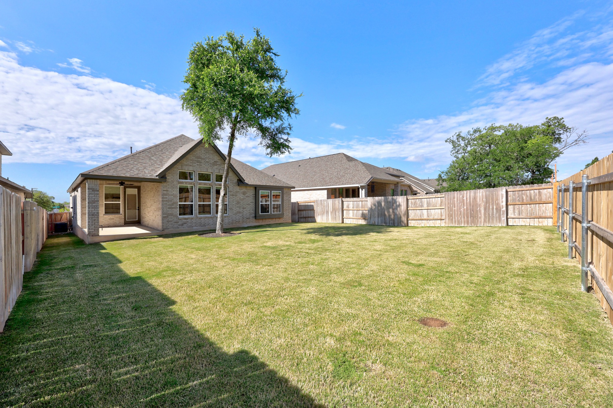 6000 Sean Paul Lane Georgetown, TX 78628 - Photo 35 of 35 Back of property featuring a fenced backyard, brick siding, a patio, and a shingled roof