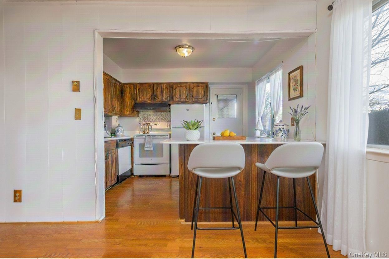 306 Old Country Road, Unit 306 Elmsford, NY 10523 - Photo 12 of 35 Virtually staged photo of kitchen, featuring a peninsula with counter-height seating.