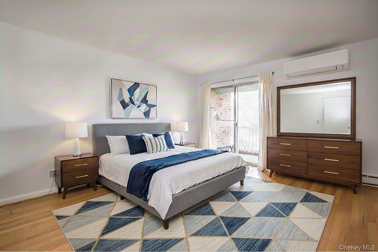 306 Old Country Road, Unit 306 Elmsford, NY 10523 - Photo 17 of 35 Virtually staged photo of the primary bedroom, featuring the sliding glass doors to the patio.