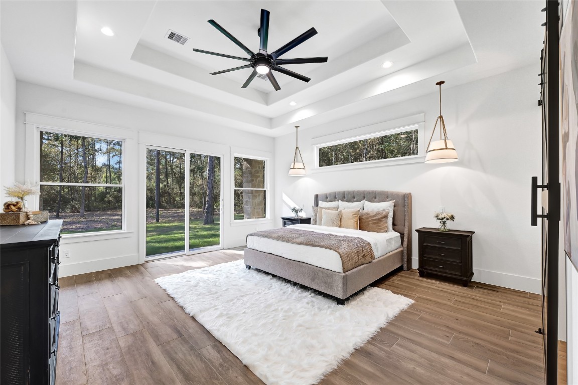 7244 Red Oak Grove Road Montgomery, TX 77316 - Photo 15 of 49 a spacious bedroom with a large bed and a chandelier fan