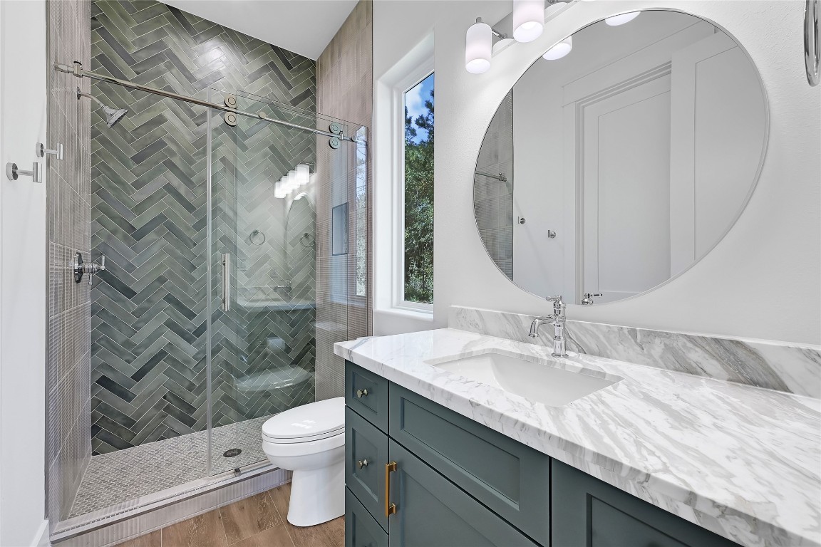 7244 Red Oak Grove Road Montgomery, TX 77316 - Photo 29 of 49 a bathroom with a granite countertop sink toilet a mirror and shower