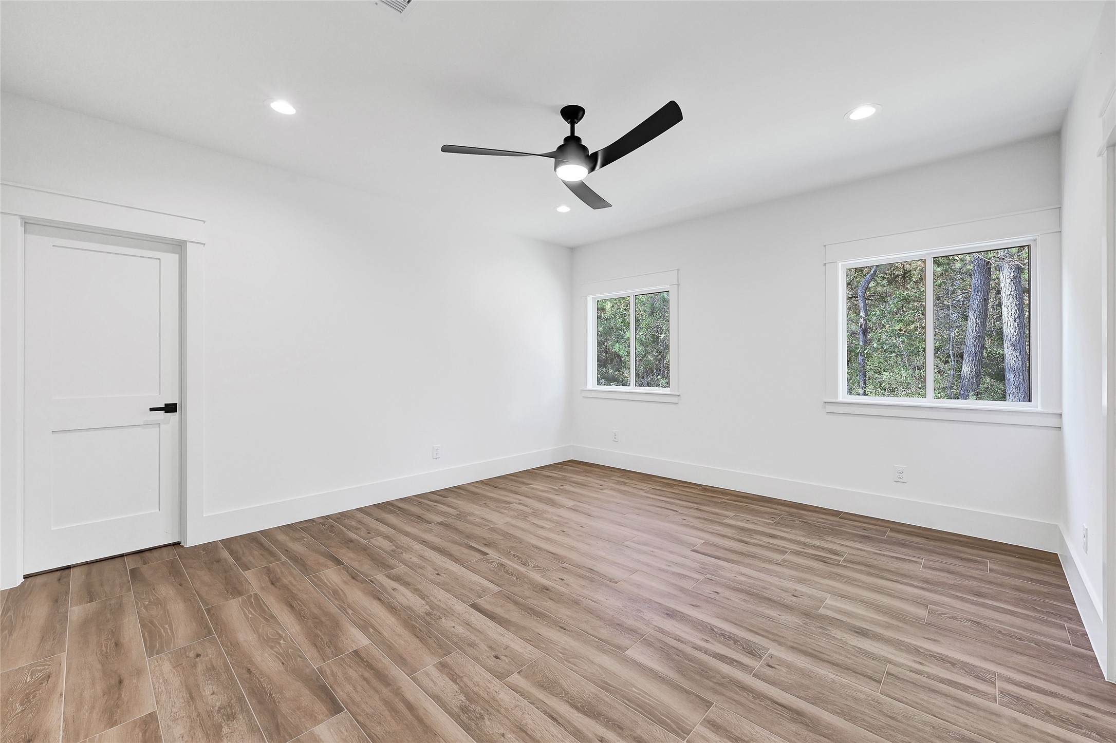 7244 Red Oak Grove Road Montgomery, TX 77316 - Photo 38 of 49 an empty room with wooden floor ceiling fan and windows