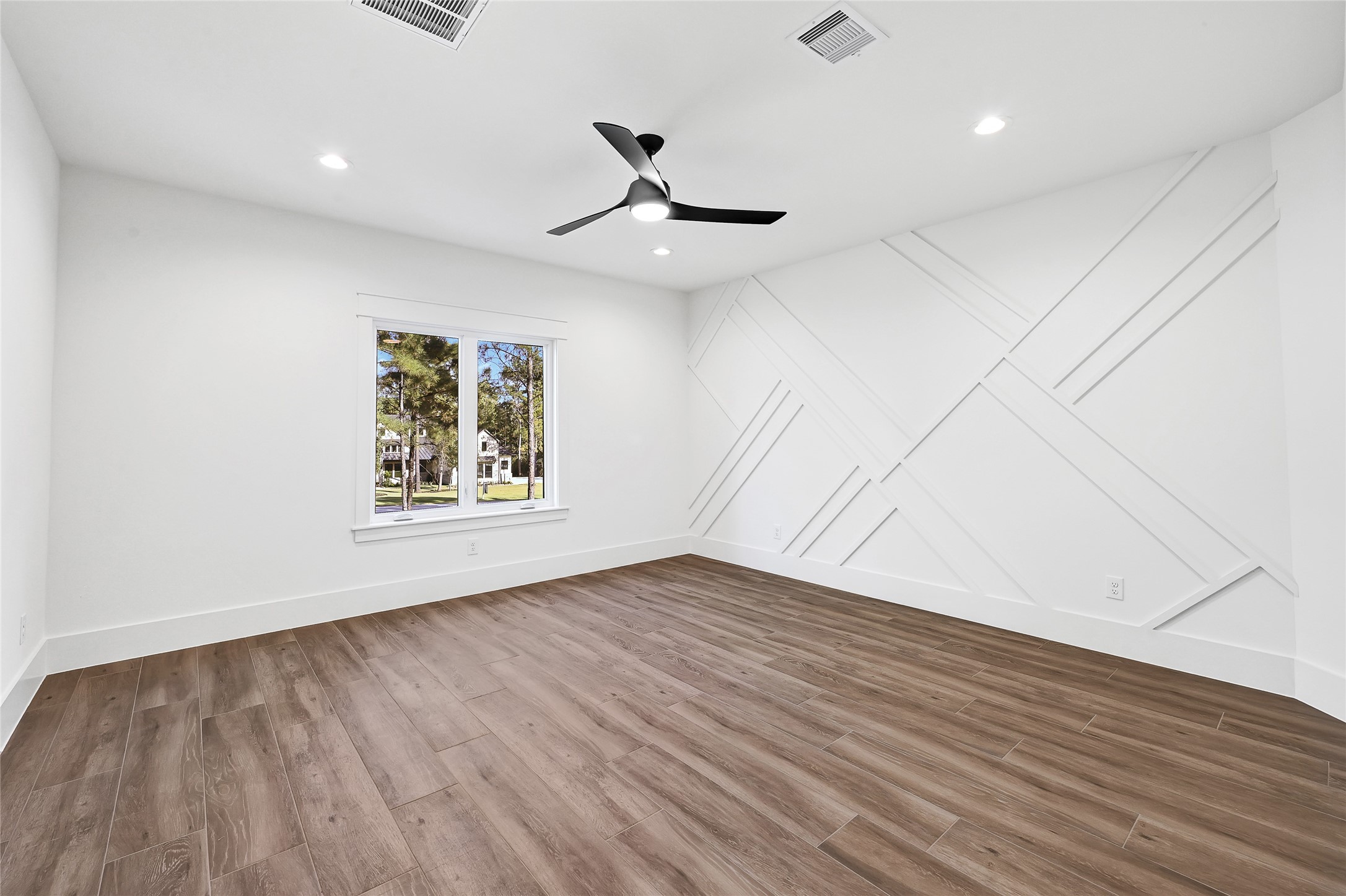 7244 Red Oak Grove Road Montgomery, TX 77316 - Photo 42 of 49 an empty room with wooden floor a ceiling fan and windows