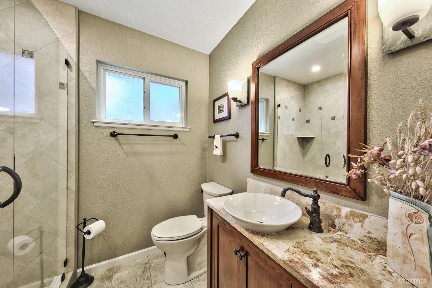 712 Sand Harbor Road South Lake Tahoe, CA 96150 - Photo 18 of 38 a bathroom with a granite countertop sink toilet and shower
