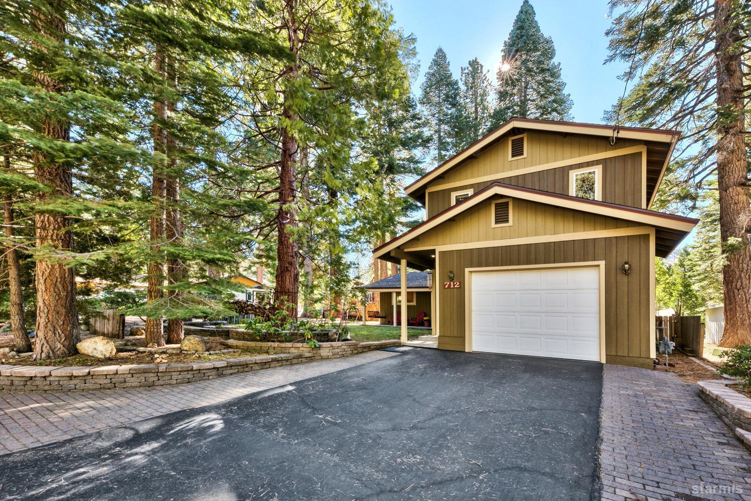 712 Sand Harbor Road South Lake Tahoe, CA 96150 - Photo 2 of 38 a front view of a house with a yard and garage