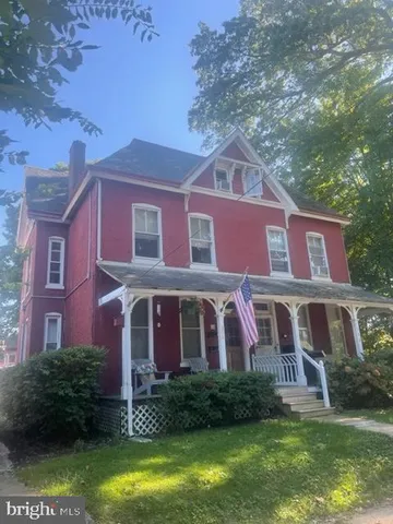 a front view of a house with yard and green space