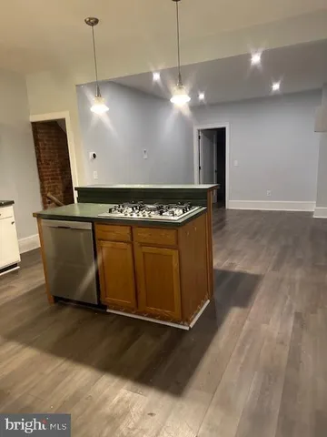 a large kitchen with stainless steel appliances a large counter top a stove and a refrigerator