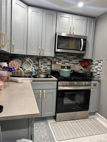 a kitchen with stainless steel appliances a stove a microwave and sink