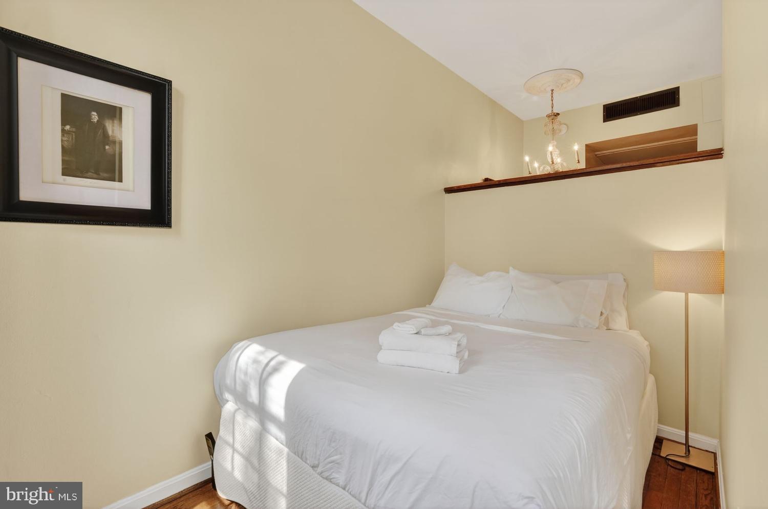 11 2nd Street Northeast, Unit 208 Washington, DC 20002 - Photo 12 of 12 a large bed sitting in a bedroom next to a lamp