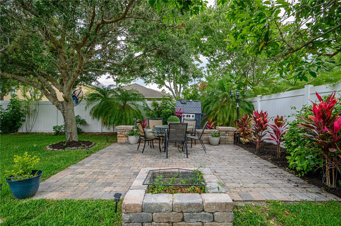 114 Drake Way Sebastian, FL 32958 - Photo 24 of 34 a view of a patio with table and chairs potted plants and a large tree