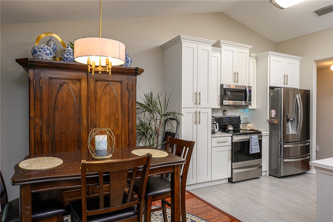 114 Drake Way Sebastian, FL 32958 - Photo 5 of 34 a kitchen with stainless steel appliances a stove a refrigerator and a chandelier