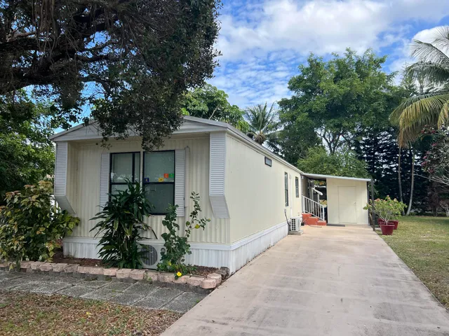 a white house with tree in front of it